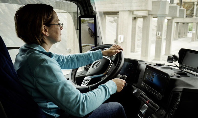 Mujer conduciendo un camión Mercedes Benz